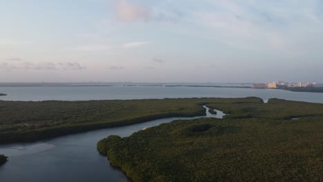Luftaufnahme-Der-Landschaft-In-Der-Nähe-Der-Punta-Nizuc-Brücke-In-Cancun,-Mexiko,-Mit-Blick-Auf-Das-Azurblaue-Wasser-Des-Karibischen-Meeres-Und-Atemberaubendem-Kontrast-Zum-Lebendigen-Grün-Der-Mangroven