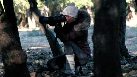 Zeitlupenaufnahme-Eines-Naturfotografen,-Der-Sich-Zwischen-Bäumen-Versteckt