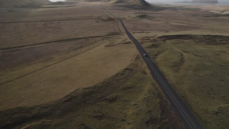 Long-straight-road-through-Iceland-volcanic-countryside,-concept-roadtrip