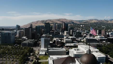 Drone-shot-of-the-American-flag-flying-over-Salt-Lake-City-on-a-sunny-day