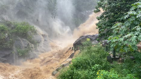 Handheld-Shot-of-Ravana-Falls-at-High-Discharge-After-Heavy-Rainfall-Flooding-Muddy-Water-in-Ella-Sri-Lanka