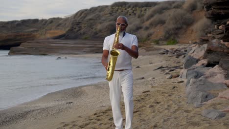 Slow-front-on-shot-of-a-man-playing-the-saxophone-on-the-beach