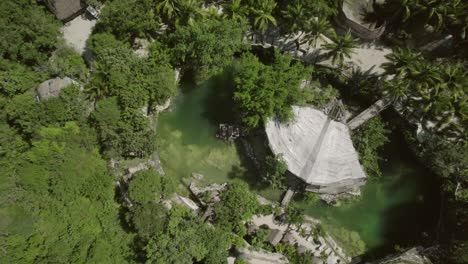 Cinematic-clip-going-upwards-of-a-pond-in-the-middle-of-a-rainforest-and-a-lush-vegetation-of-a-resort