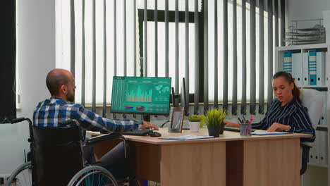 Businessman-in-wheelchair-working-in-business-office
