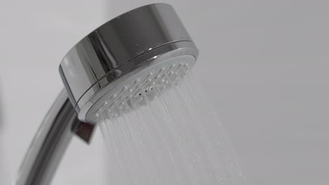 Duschkopf-Im-Badezimmer-Mit-Fließenden-Wassertropfen.-Wassertropfen-Im-Duschkopf