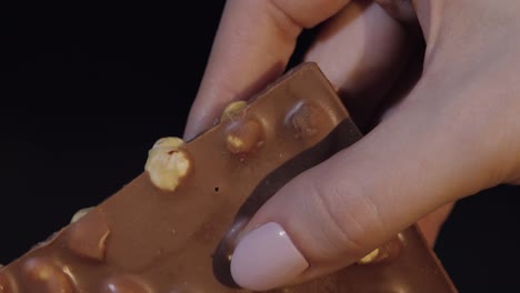 Black-chocolate-block-bar-in-woman's-hand-close-up