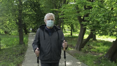 Anciano-Activo-Con-Máscara-Entrenando-Caminata-Nórdica-En-El-Parque-Durante-La-Cuarentena