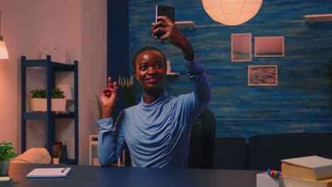 African-employee-taking-a-selfie-using-mobile-phone-smiling-at-camera