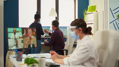 Businesswoman-talking-on-video-call-wearing-protection-mask