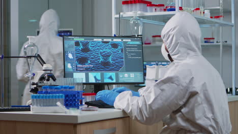 Medical-scientist-in-ppe-suit-working-with-DNA-scan-image