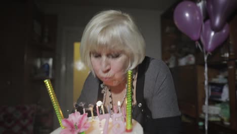Glückliche-ältere-Frau,-Die-Kuchen-Hält.-Feiern.-Geburtstagskerzen-Ausblasen