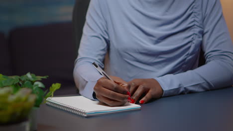 Close-up-of-african-businesswoman-writing-list-of-tasks