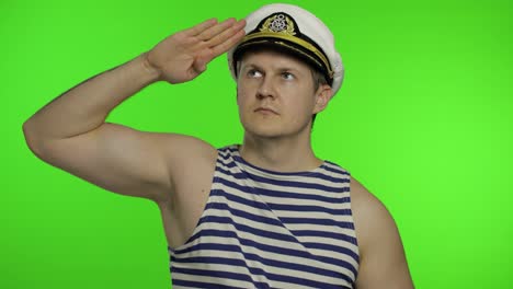 Young-sailor-man-salutes-with-hand,-looking-up.-Seaman-guy-in-sailor's-vests