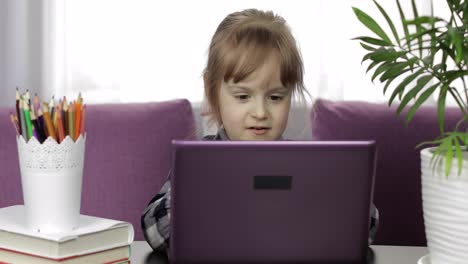 Girl-doing-lessons-at-home-using-digital-laptop-computer.-Distance-education