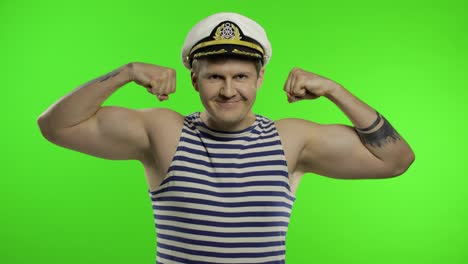 Young-sailor-man-shows-muscles,-looking-at-camera.-Seaman-guy-in-sailor's-vest
