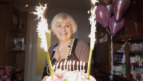 Happy-senior-woman-holding-cake.-Celebrating-birthday-anniversary-at-home