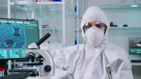 Tired-laboratory-doctor-with-overall-suit-looking-at-camera