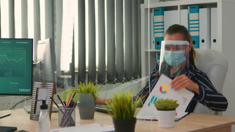 Manager-with-protection-mask-working-in-new-normal-office