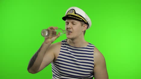 Young-sailor-man-drinks-vodka.-Seaman-guy-in-sailor's-vest-shirt.-Chroma-key
