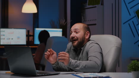 Happy-cheerful-businessman-smiling-while-looking-at-laptop-computer-display