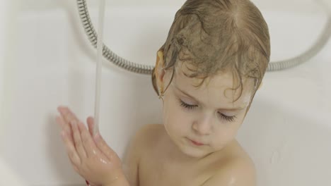 Attractive-three-years-old-girl-takes-a-bath.-Cleaning-and-washing-hair