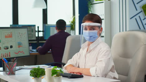 Manager-woman-with-visor-and-protection-mask-looking-at-camera