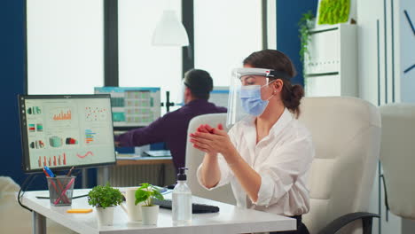 Entrepreneur-with-protection-mask-applying-sanitizer-gel-on-hands