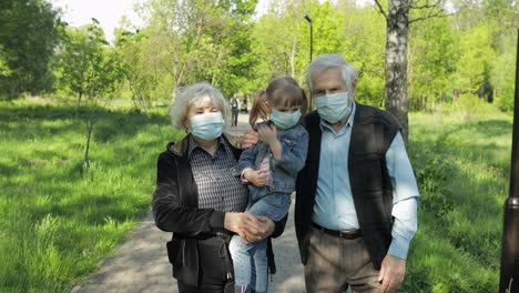 Großeltern-Mit-Enkelin-Nehmen-Nach-Ende-Der-Coronavirus-Quarantäne-Die-Masken-Ab