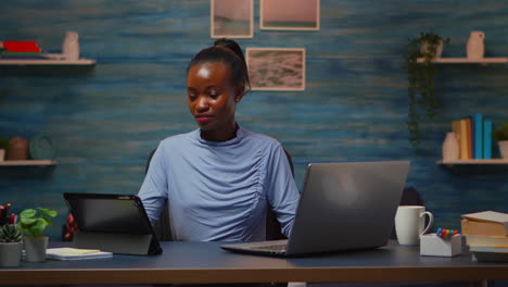 Mujer-Africana-Usando-Computadora-Portátil-Y-Tableta-Al-Mismo-Tiempo-Con-Exceso-De-Trabajo