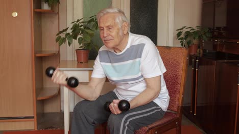 Senior-elderly-caucasian-man-doing-weight-lifting-dumbbell-exercising-at-home