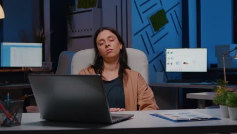 Müde-überarbeitete-Geschäftsfrau,-Die-Im-Büro-Eines-Startup-Unternehmens-Auf-Einem-Schreibtischstuhl-Schläft.