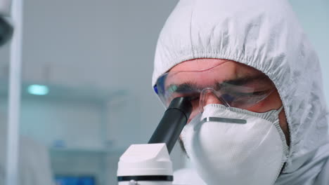 Close-up-of-scientist-carrying-out-genetic-analysis-using-microscope