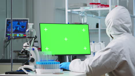Arzt-Mit-Overall,-Der-Am-Computer-Mit-Grünem-Bildschirm-Arbeitet