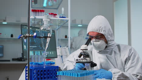 Biologist-doctor-in-coverall-checking-DNA-sample-using-microscope