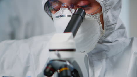 Close-up-of-experienced-biologist-in-ppe-suit-working-on-microscopes
