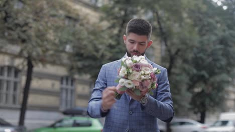 Groom-with-a-black-beard-with-wedding-bouquet-on-the-street.-Wedding-day