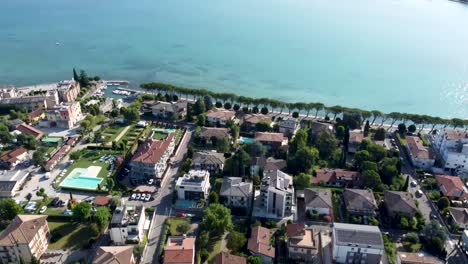 Enchanting-houses-and-tranquil-shores-in-Peschiera-del-Garda,-aerial-tilt-up
