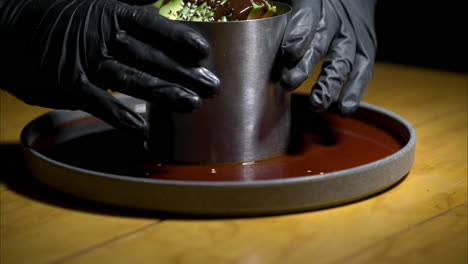 Slow-motion-close-up-of-a-waiter-with-black-latex-gloves-serving-a-seafood-timbale-at-a-traditional-mexican-restaurant