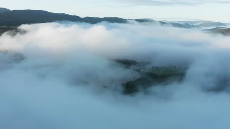 Flight-above-thick-clouds-hanging-above-the-Otra-River,-Norway