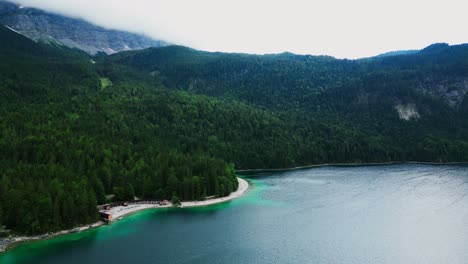 Aerial-of-Lake-Eibsee-at-the-base-of-mountain-Zugspitze,-Scenic-lake-in-the-mountains-surrounded-by-pine-tree-forest,-Germany