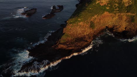 Aerial-ocean-wave-crash-rock-cliff-edge-circular-shot,-Norfolk-Island