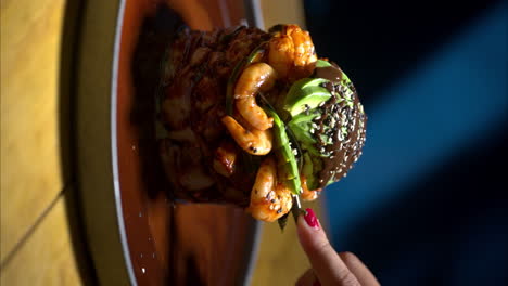 Vertical-slow-motion-close-up-of-female-hand-woman-eating-a-seafood-shrimp-timbale-at-a-traditional-mexican-restaurant
