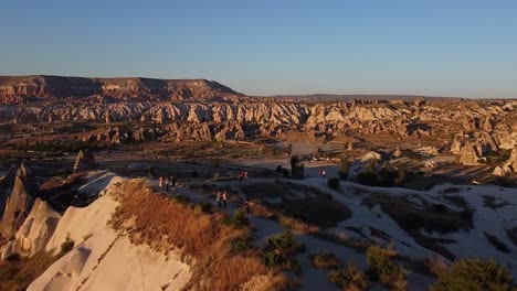 Aerial-view-of-a-panoramic-viewpoint-with-people-watching-the-sunset-above-Cappadocia