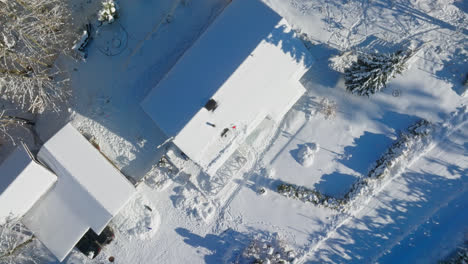 Aerial-view-rotating-above-tools-at-partly-snowy-solar-panels-on-a-house-roof