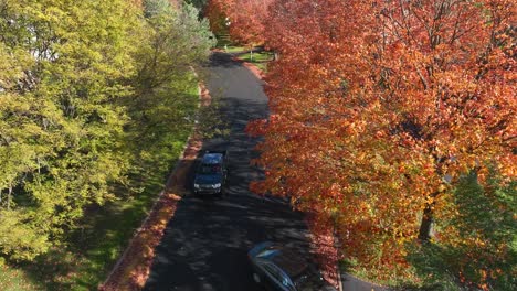 Cars-driving-in-New-England-neighborhood-during-autumn