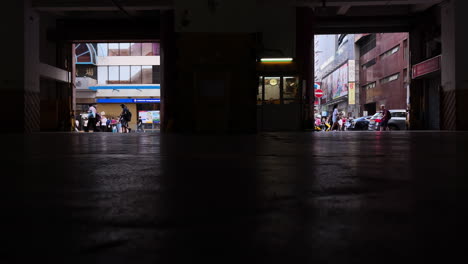 Video-of-people-walking-on-the-streets-of-Hong-Kong,-recorded-from-inside-the-parking-lot-inside-the-building