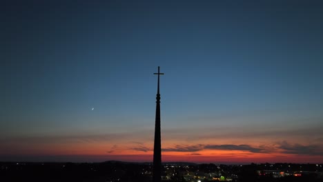 Kirchturm-Silhouette-Vor-Einem-Sonnenuntergangshimmel-Mit-Einem-Halbmond