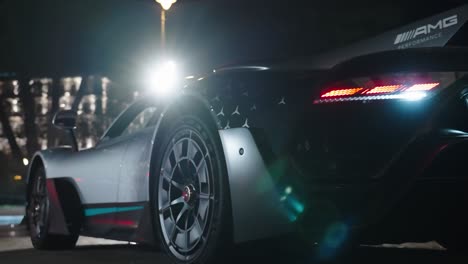 Rear-look-of-Project-One-car-with-brake-lights-and-spotlight-in-background