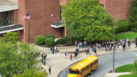 Yellow-school-buses-arriving-at-USA-high-school-at-dismissal