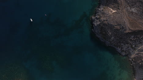 Aerial-shot-over-Yachts-in-a-bay-towards-sandy-beach